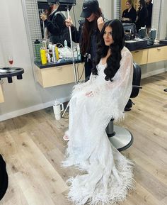 a woman is getting her hair done in a salon while another person sits on the chair