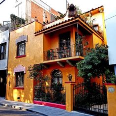 an orange and yellow building with wrought iron railings