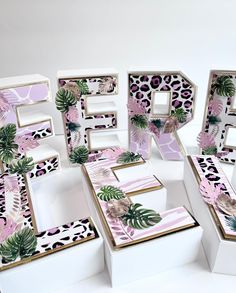 the letters are made out of cardboard and decorated with tropical leaves, palm trees, and leopard prints