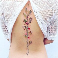 the back of a woman's stomach with flowers and leaves on her lower side