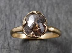 a close up of a gold ring with a brown diamond