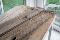 a wooden bench sitting next to a window