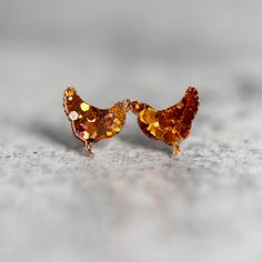 the small earrings are made out of gold and orange colored glass beads, with tiny crystals embedded in them