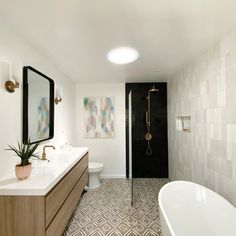 a bathroom with a tub, sink and mirror