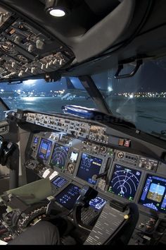 an airplane cockpit at night with the lights on