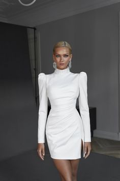 a model walks down the runway in a white dress