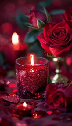 a candle and some red roses on a table