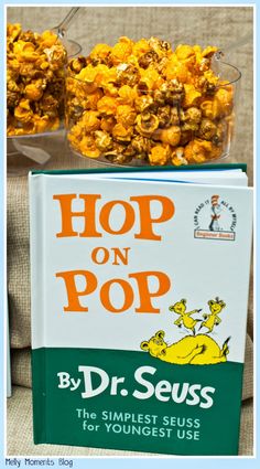 a book and bowl of popcorn sitting on top of a couch with the title hop on pop by dr seuss