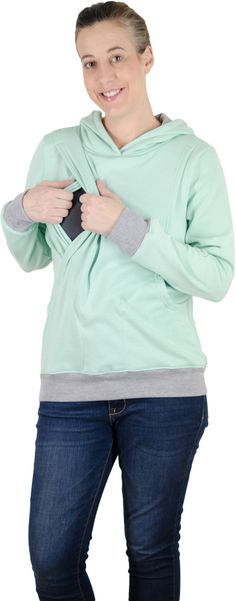 a woman is standing with her hands on her hips and wearing a green hoodie