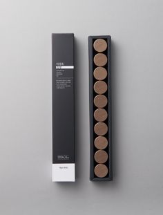 an empty black box with eight brown circles in it and the packaging next to it