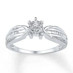 a white gold ring with a diamond in the center and leaves on it's sides