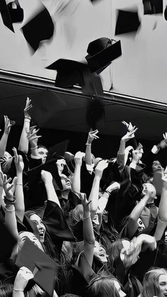 black and white photograph of graduates throwing their caps in the air