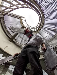 a man standing on top of a skateboard in front of a circular metal structure