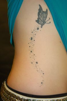 the back of a woman's stomach with stars and a butterfly tattoo on it