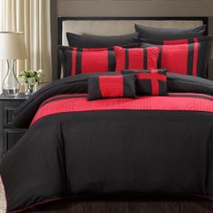 a black and red bed with pillows on it