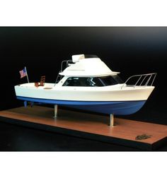 a white and blue boat sitting on top of a wooden stand