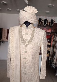 a mannequin wearing a white outfit and pearls