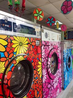 colorfully painted washers and dryers are lined up in a row