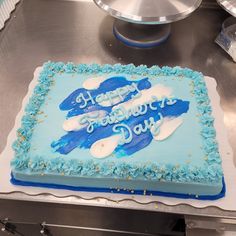 a blue and white birthday cake on a table