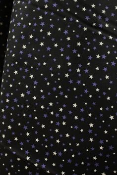 a black background with purple and white stars on it's side, all over