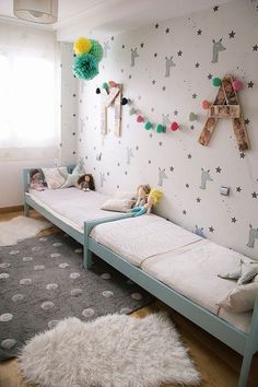 there are two twin beds in the room with stars and moon wallpaper on the walls