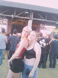 two women standing next to each other at a music festival