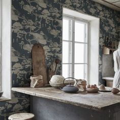 a woman standing in a kitchen next to a window