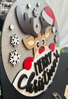 a merry christmas sign with a reindeer and snowflakes on it's face