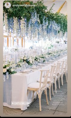 an image of a table set up with flowers and greenery hanging from the ceiling