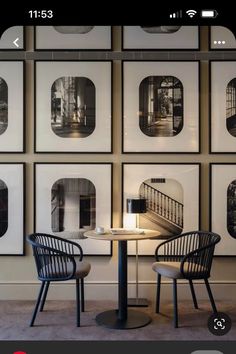 two chairs sitting at a table in front of pictures