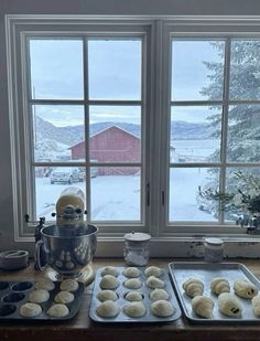 doughnuts are being prepared in front of the windows on a kitchen countertop