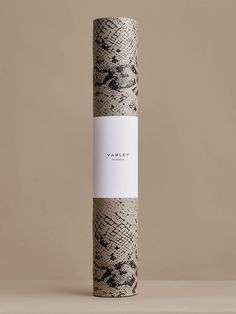 a yoga mat with a white and black snake skin print on it, in front of a beige background