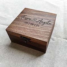 a wooden box with the name and date engraved on it sitting on a white surface