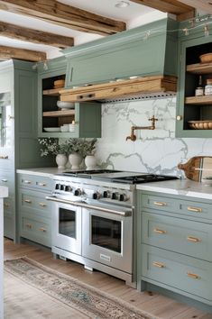 a kitchen with an oven, stove and cabinets painted in shades of blue and green