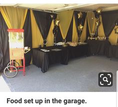 a room with black and yellow decorations on the wall next to a table filled with food