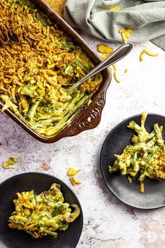 broccoli casserole on two black plates with spoons