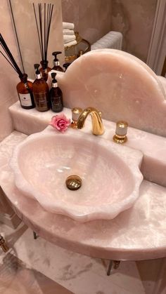 a bathroom sink with soap and lotion on it's counter next to a mirror