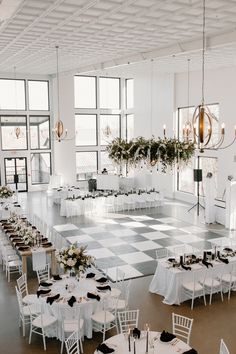 an empty banquet hall with white tables and black and white checkered tablecloths