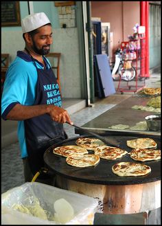 a man cooking food on an outdoor grill