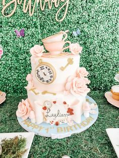 there is a cake that has been decorated with pink flowers and a clock on it