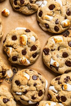 cookies with marshmallows and chocolate chips are arranged on a baking sheet, ready to be eaten