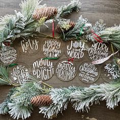 christmas ornaments are laid out on a wooden surface with pine cones and evergreen branches around them