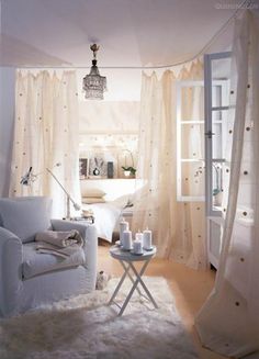 a living room filled with white furniture and curtains