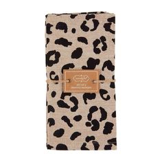 a brown and black animal print napkin with a leather tag on the front, sitting on top of a white background