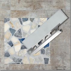 a knife is laying on top of a mosaic tile floor with blue and white stones