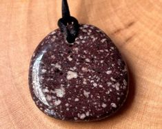 a rock with white speckles on it sitting on top of a wooden table