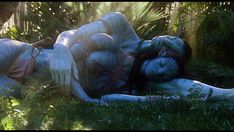 a woman laying in the grass with her face covered by white skin and makeup on