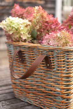 a basket filled with flowers sitting on top of a wooden table