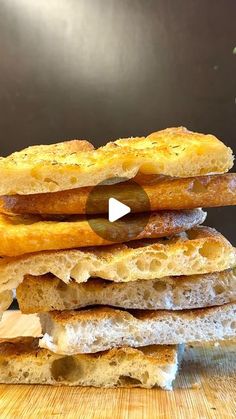 a stack of breads sitting on top of a wooden table