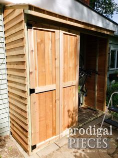 a wooden shed with the door open and bicycle parked in it's side yard